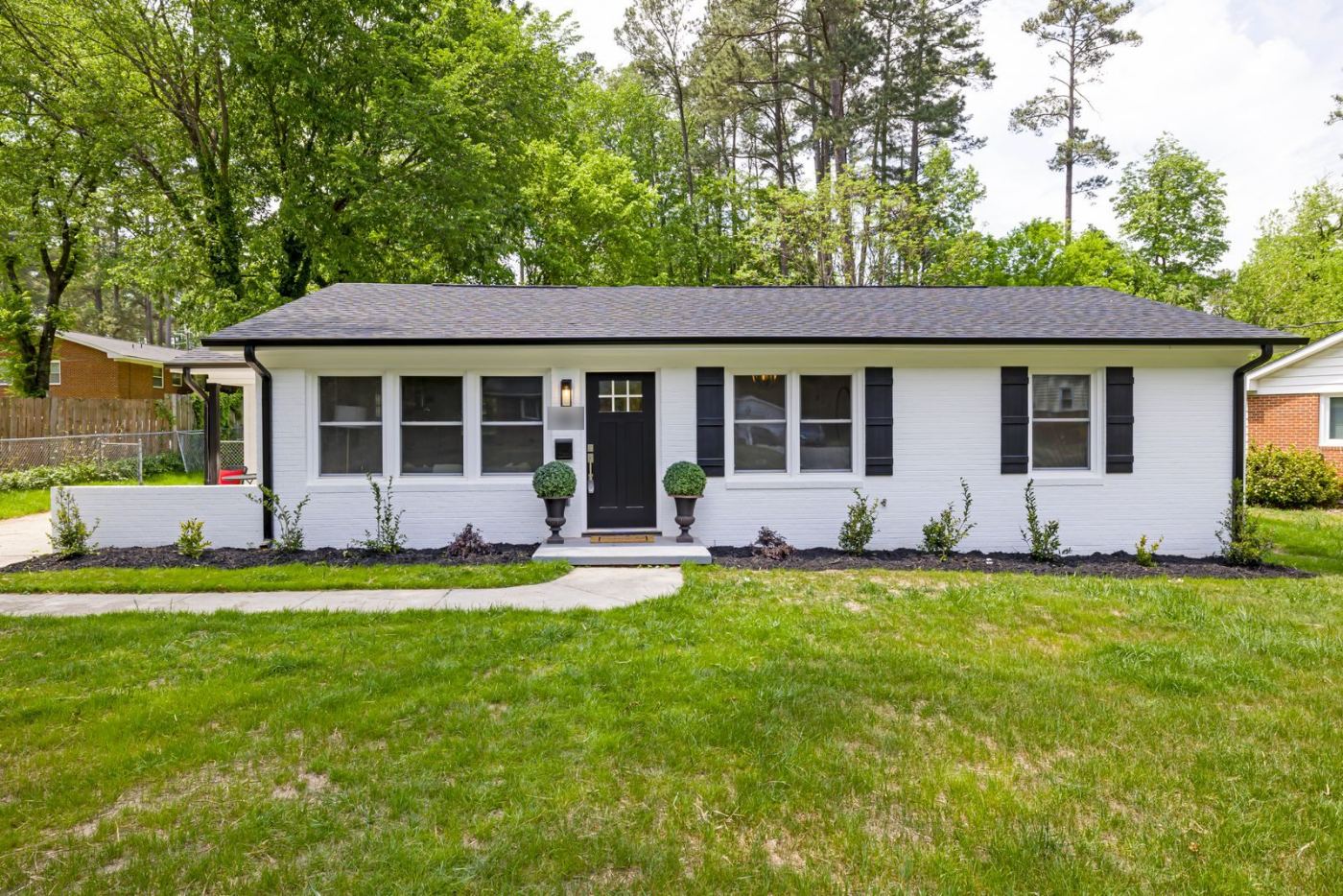 Single-story home with a front lawn and trees